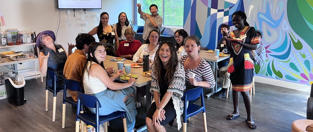 FLOWS members sitting around a table smiling and laughing